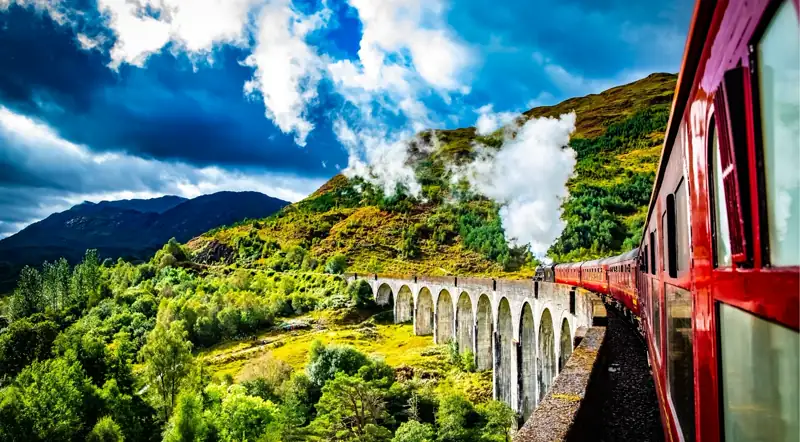 View from the Jacobite train crossing the Glenfinnan Viaduct under a dramatic sky